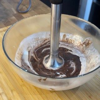 Una ciotola di salsa al cioccolato con un frullatore che sporge da essa