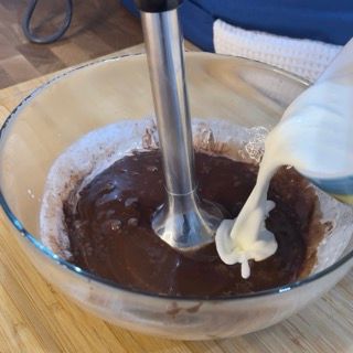 Una persona sta versando il latte in una ciotola di salsa al cioccolato