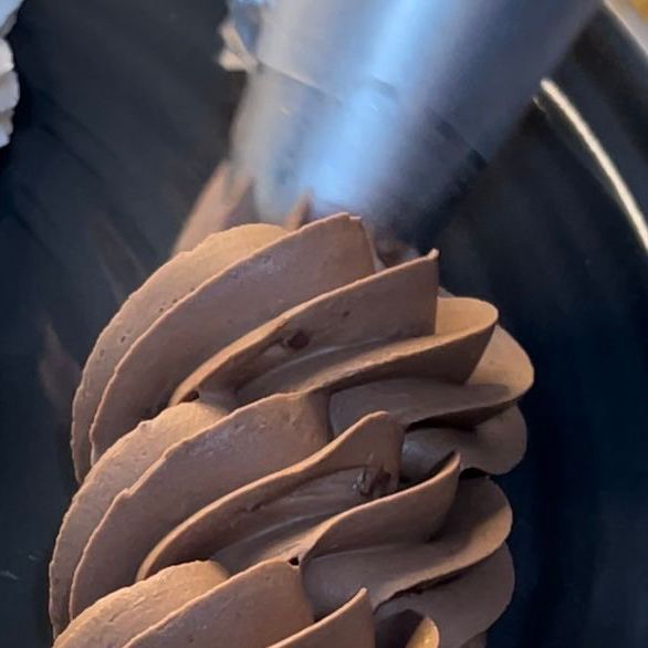 Un primo piano della glassa al cioccolato che viene versata su una torta