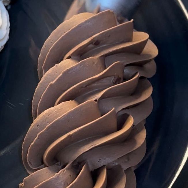 Un primo piano di glassa al cioccolato su un piatto nero