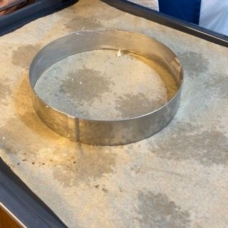 Un anello di metallo è appoggiato su un pezzo di carta oleata