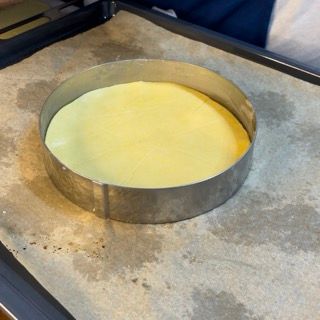 Una torta gialla in un anello di metallo su un vassoio