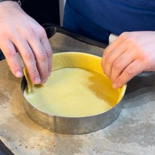Una persona sta preparando una torta in una teglia di metallo