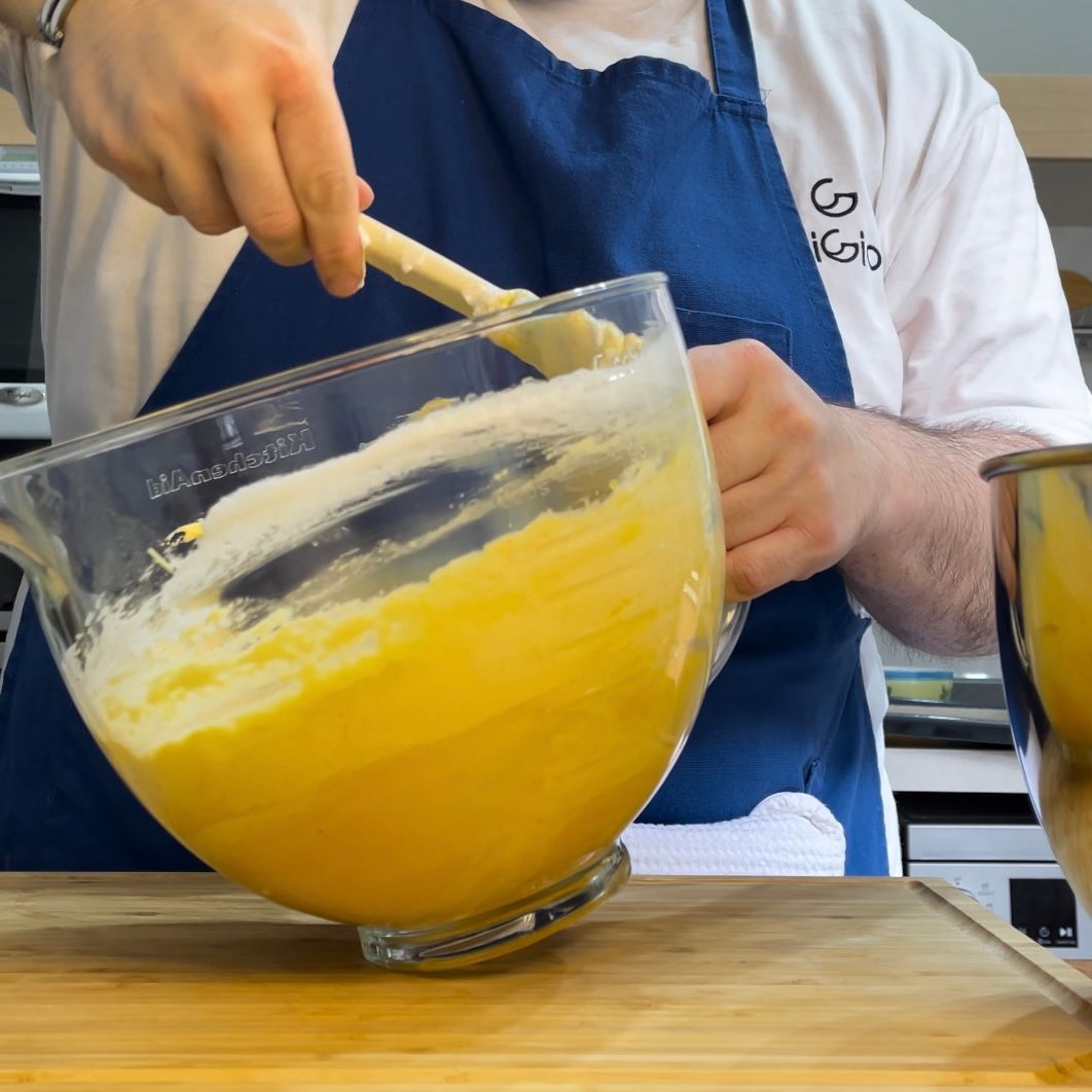 Primo inserimento di due cucchiai di albumi nella base choux per alleggerirla.