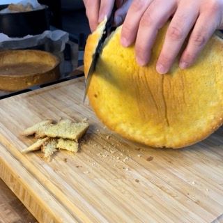 Una persona sta tagliando un pezzo di pane su un tagliere