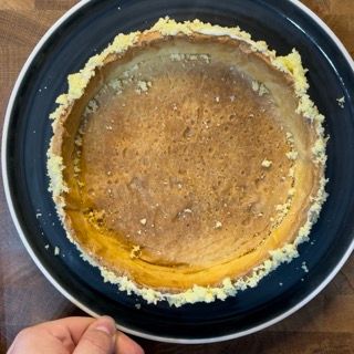Una persona tiene in mano un piatto blu con una torta sopra