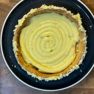 Una torta con un vortice di glassa gialla su un piatto blu