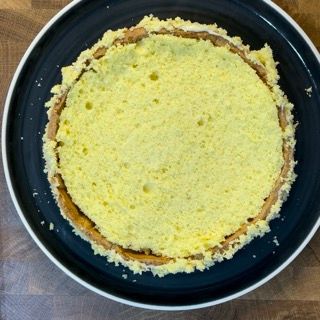 Un piatto blu con una torta gialla sopra