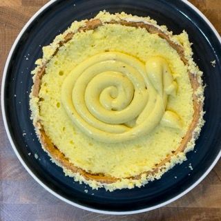 Un piatto blu sormontato da un vortice di glassa gialla