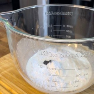 Una tazza graduata KitchenAid piena di polvere bianca