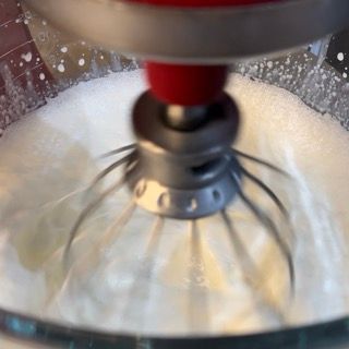 Un primo piano di un mixer con panna montata al suo interno.
