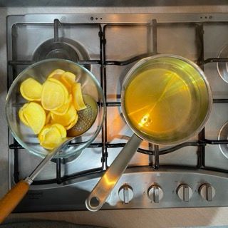 Un fornello con una ciotola di patatine e una pentola di liquido
