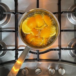 Una pentola di arance e limoni che cuociono su un fornello