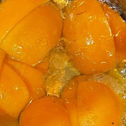 Un primo piano di una ciotola di pesche sciroppate.