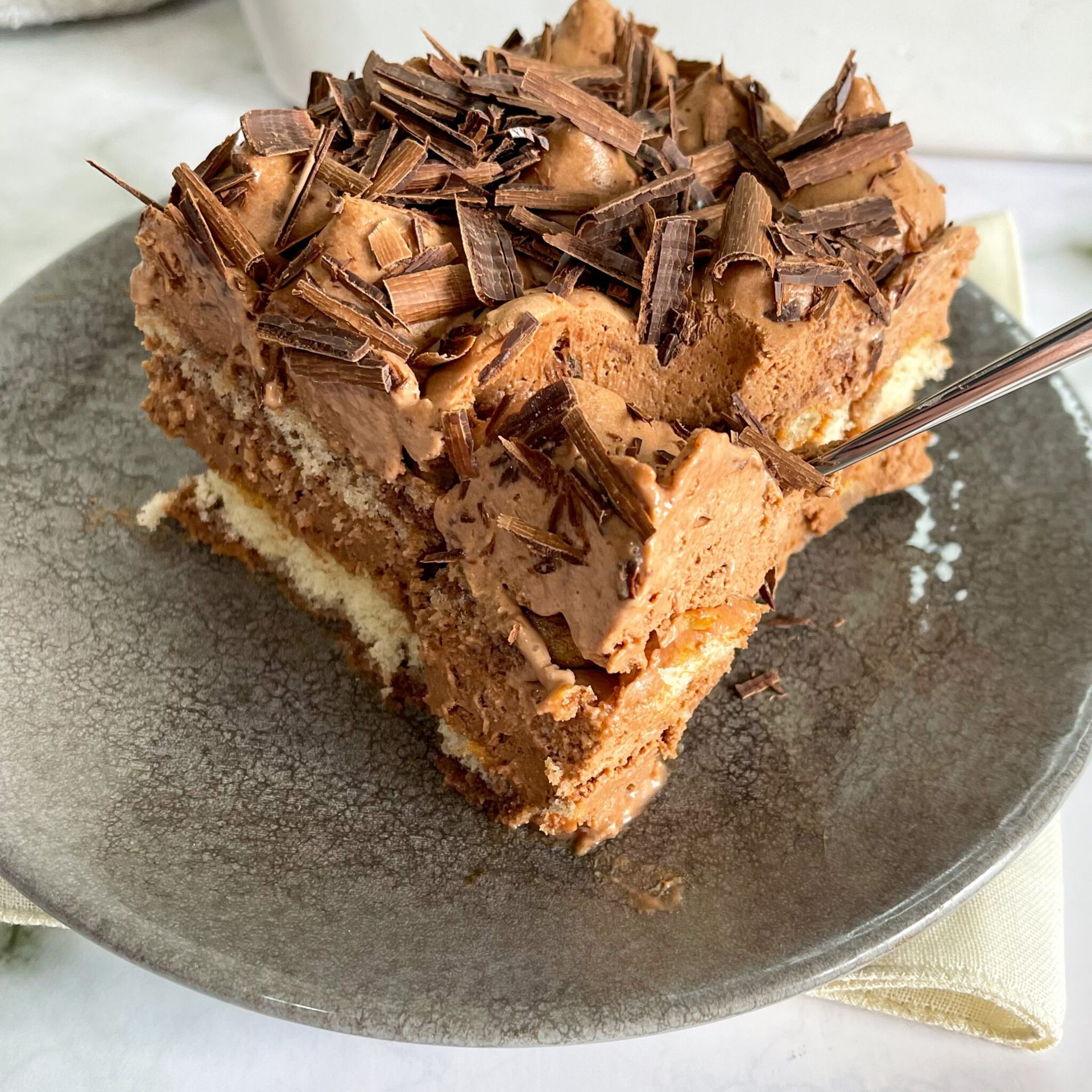 Un pezzo di torta al cioccolato su un piatto con una forchetta.