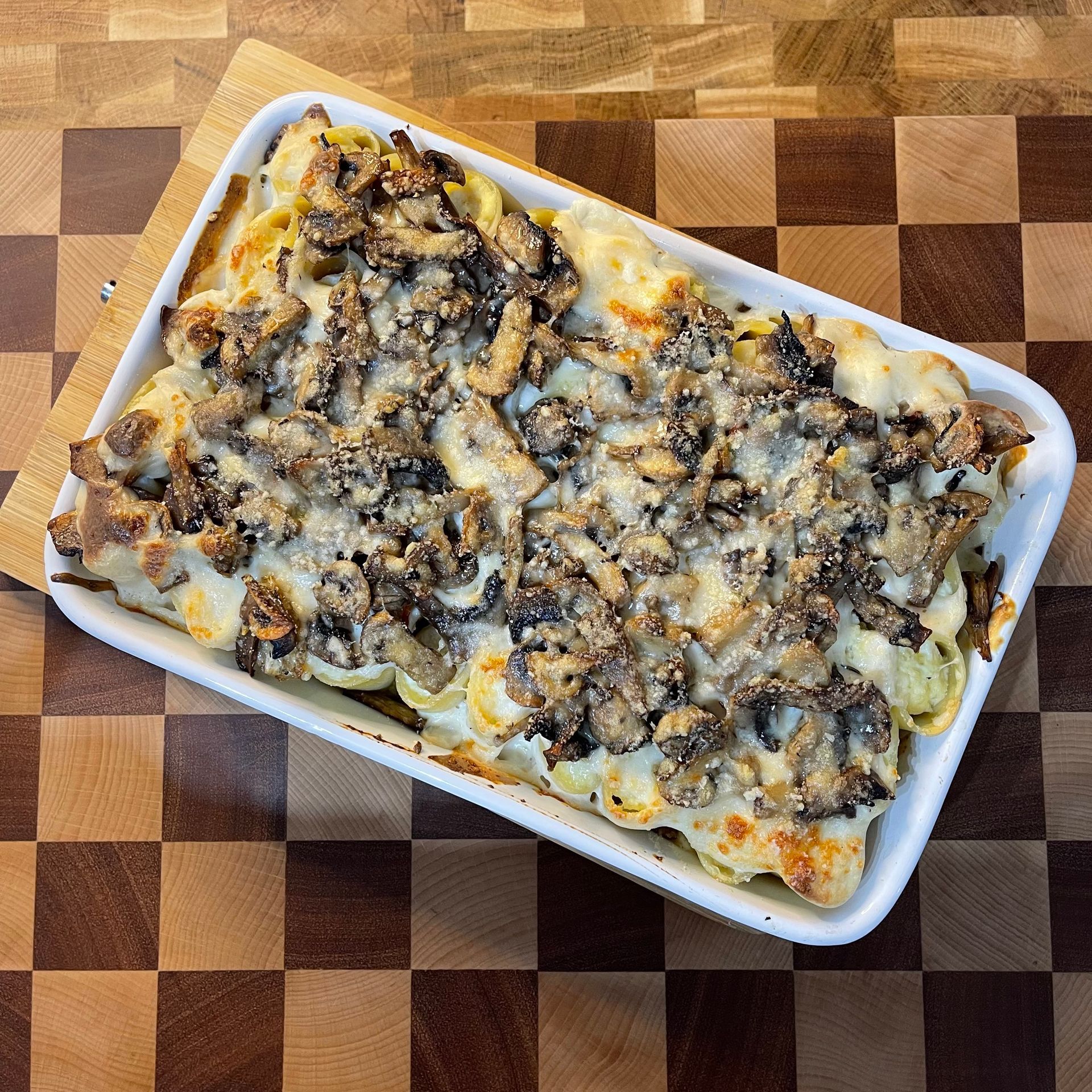 Una casseruola è appoggiata su un tagliere di legno.
