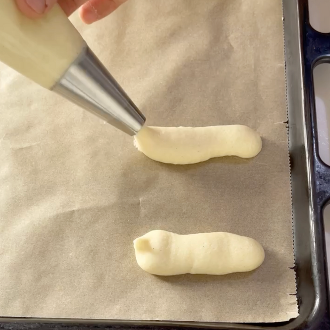 Si usa una tasca da pasticcere per spalmare la glassa su una teglia da forno