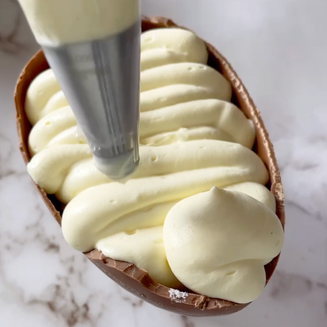 Un uovo di cioccolato viene decorato con panna montata