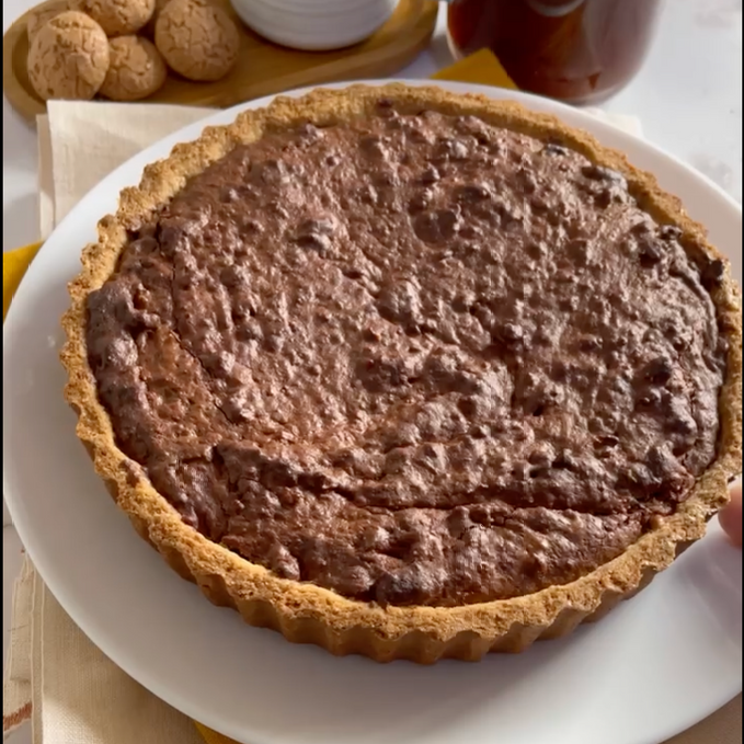 Una torta al cioccolato è appoggiata su un piatto bianco