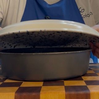 Capovolgimento delicato della torta su piatto da portata con rimozione della carta da forno sul fondo.