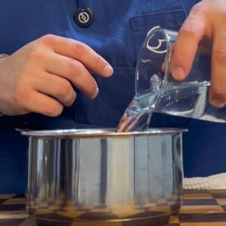 Spicchi d'aglio messi in un pentolino con 200ml di acqua ,base per la crema di aglio fatta in casa.