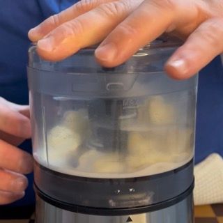 Controllo della texture granulosa del composto d'aglio all'interno del boccale del mixer.
