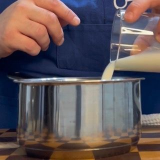 Spicchi d'aglio messi in un pentolino con 40ml di latte, base per la crema di aglio fatta in casa.