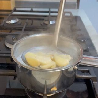 Utilizzo di una schiumarola per scolare velocemente gli spicchi d'aglio non appena inizia il bollore