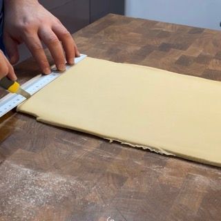 ritaglio triangoli dalla pasta croissant per formatura croissant francesi