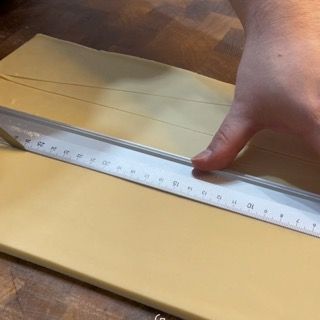 ritaglio triangoli dalla pasta croissant per formatura croissant francesi