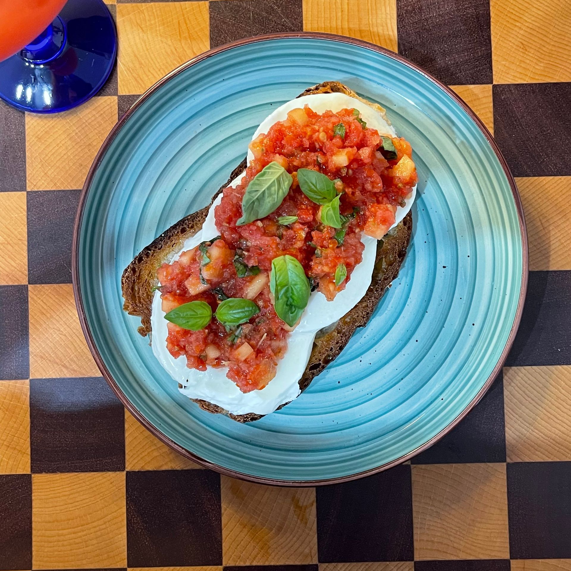 Crostone caprese con pomodoro grattugiato stile pan con tomate, mozzarella di bufala e basilico fresco.
