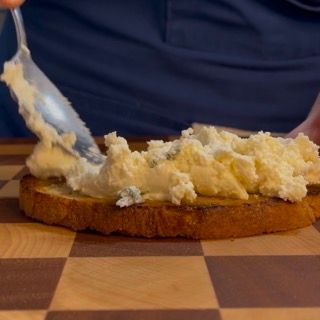 Una persona sta spalmando del burro su un pezzo di pane