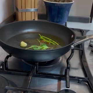 Una padella con le verdure dentro è sul fornello.