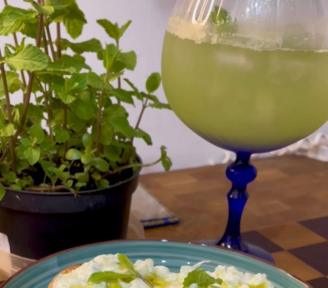 Dettaglio del mocktail cetriolo e menta con ghiaccio e ribbon di cetriolo per una ricetta cucumber fizz perfetta.