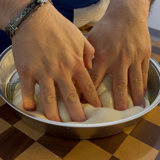 Focaccia lievitata in teglia, pronta per essere stesa