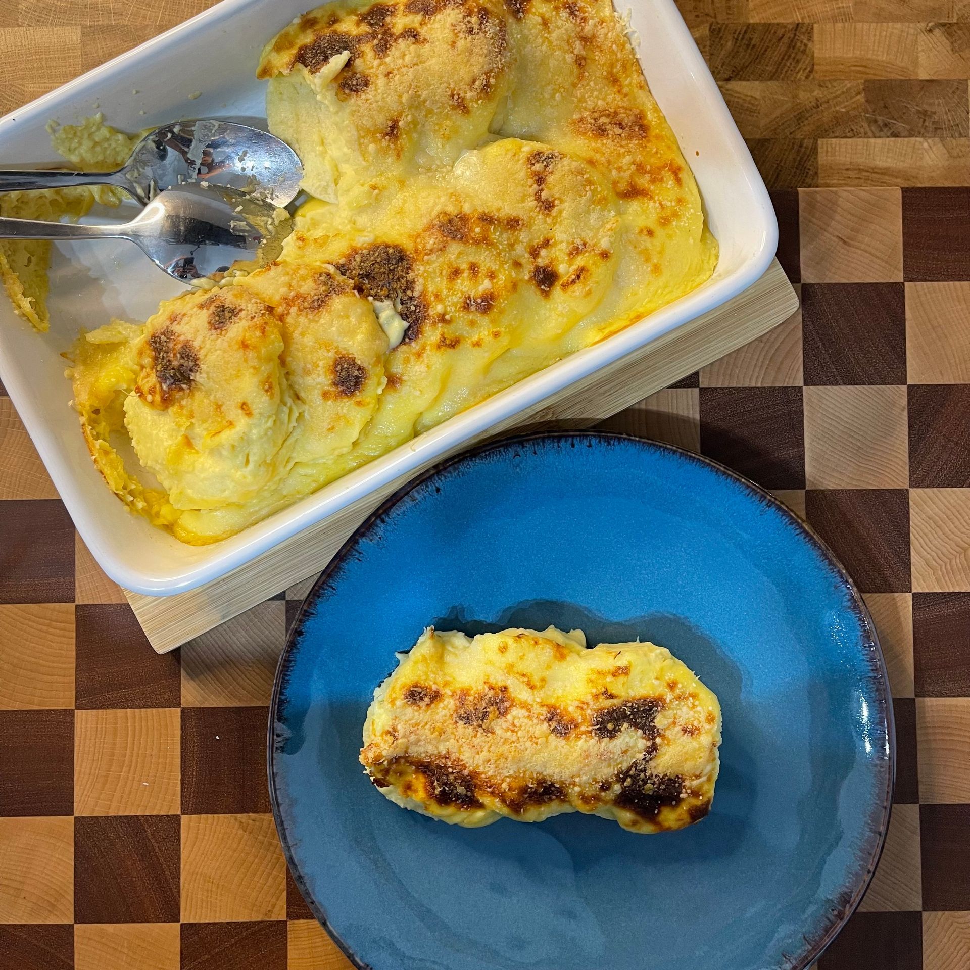 Una casseruola accanto a un piatto blu con un pezzo di cibo sopra