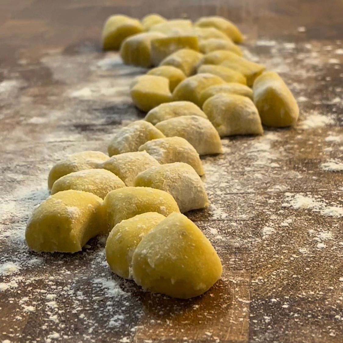 Gnocchi di patate fatti in casa su tagliere di legno, pronti per la cotturac la ricetta della nonna 