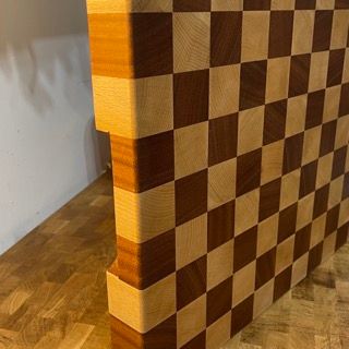 Un tagliere di legno con un motivo a scacchi