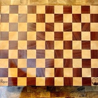 Un tagliere di legno con un motivo a scacchi è appoggiato su un tavolo.