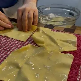 Sfoglie di lasagna adagiate su teli puliti ad asciugare