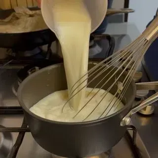 Latte freddo versato nel pentolino con il roux