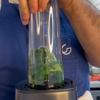 Azione del frullatore a velocità medio-alta per sminuzzare finemente l'olio al basilico e le erbe.