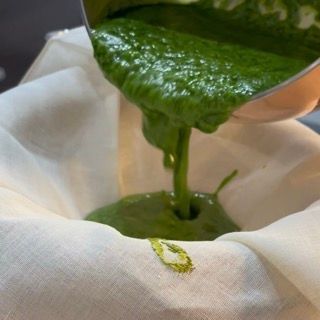 Versamento della purea riscaldata nel colino foderato con il telo di lino.