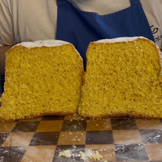 Pandoro finito spolverato di zucchero a velo, pronto per il taglio.