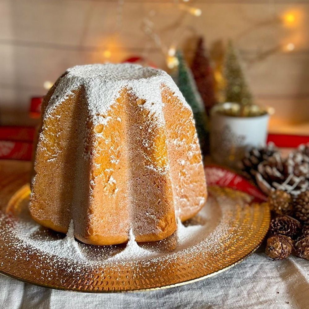 Un ciambellone ricoperto di zucchero a velo è appoggiato su un piatto.
