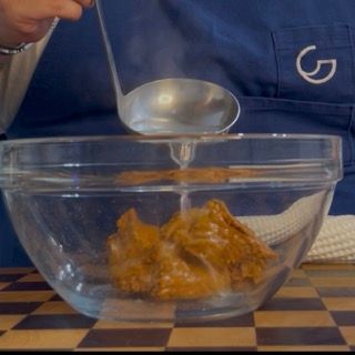 Diluizione del pesto rosso con un mestolo di acqua di cottura per non far asciugare la pasta fredda in frigo.