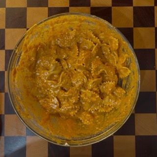 Aggiunta finale di acqua di cottura durante il mescolamento per garantire una pasta fredda cremosa al tonno.