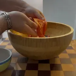 Mano che spella un peperone arrostito, mostrando la polpa tenera sottostante