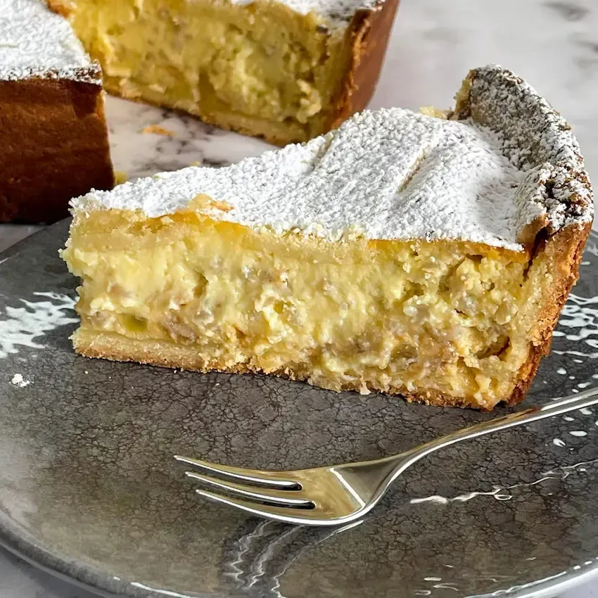 Pastiera napoletana appena sfornata con le classiche 7 strisce di frolla e zucchero a velo.