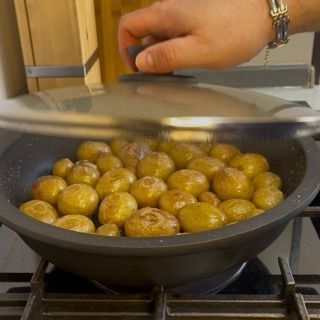 Controllo della cottura interna bucando una patata novella con i rebbi di una forchetta.